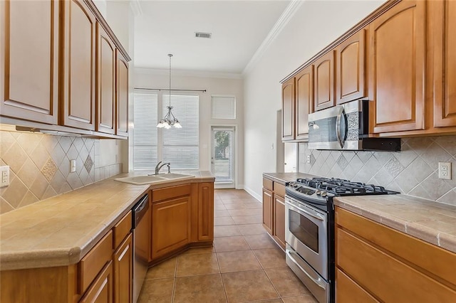 kitchen with stainless steel appliances, sink, tile countertops, an inviting chandelier, and light tile patterned flooring