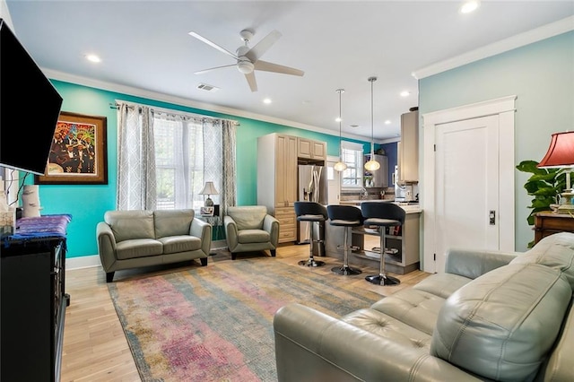 living room featuring light wood-type flooring, ceiling fan, and crown molding