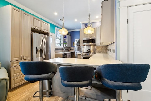 kitchen featuring stainless steel appliances, a kitchen breakfast bar, pendant lighting, and kitchen peninsula