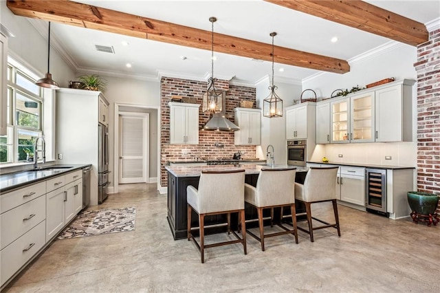 kitchen with wine cooler, appliances with stainless steel finishes, decorative light fixtures, a kitchen bar, and beamed ceiling