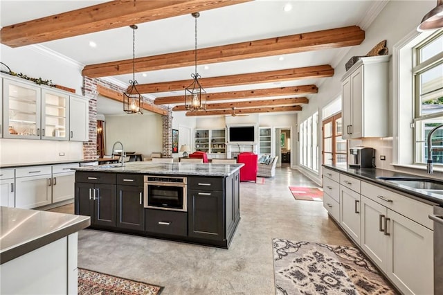 kitchen with sink, beam ceiling, backsplash, appliances with stainless steel finishes, and decorative light fixtures