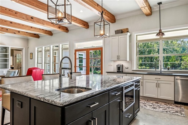 kitchen featuring sink, appliances with stainless steel finishes, a kitchen island with sink, white cabinets, and french doors