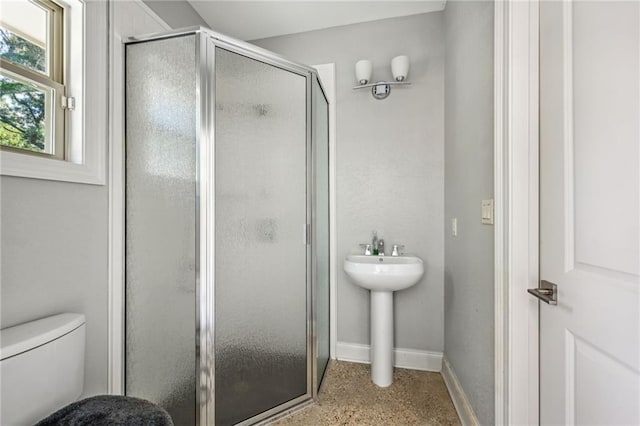 bathroom featuring toilet and an enclosed shower