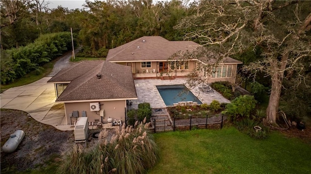 rear view of house featuring a yard, a fenced in pool, and a patio area