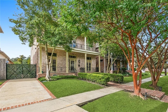 view of front of house with a porch, a balcony, and a front lawn