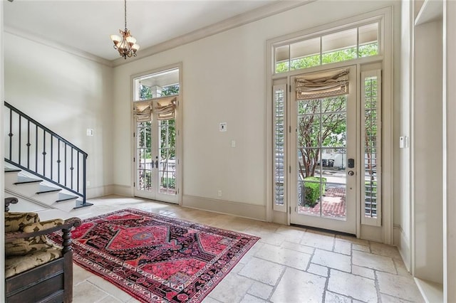 foyer entrance with crown molding and a chandelier