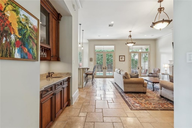 interior space with french doors, ornamental molding, and sink