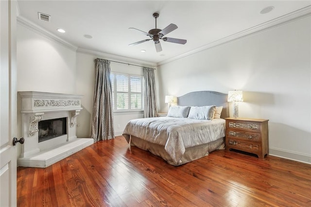 bedroom with hardwood / wood-style floors, ceiling fan, and ornamental molding