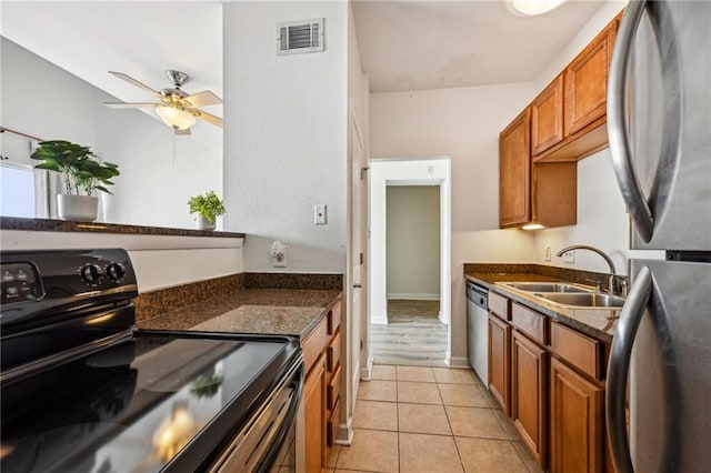 333 Julia St Unit 516, New Orleans, LA 70130 - kitchen featuring appliances with stainless steel finishes, brown cabinetry, a ceiling fan, and light tile patterned floors