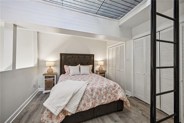 bedroom featuring dark hardwood / wood-style floors and two closets