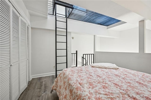 bedroom with dark hardwood / wood-style flooring and a closet