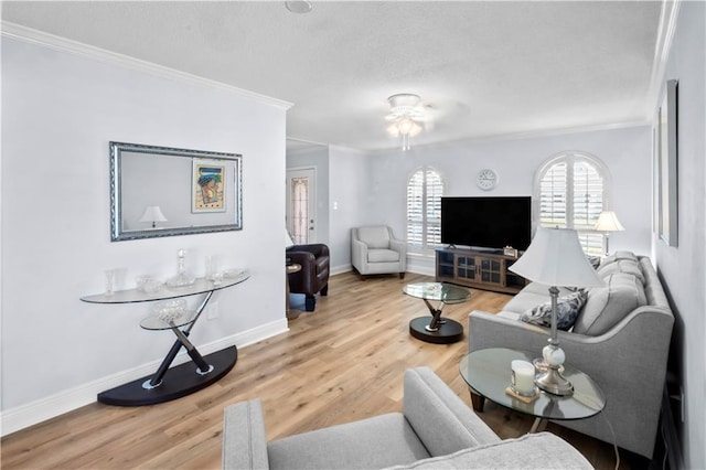 living room with wood-type flooring, ceiling fan, and ornamental molding