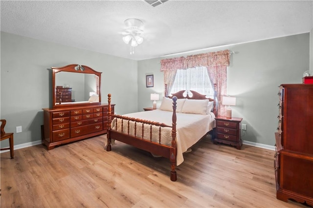 bedroom featuring a textured ceiling, light wood-type flooring, and ceiling fan