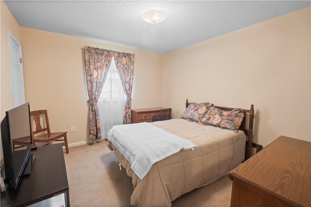 bedroom featuring a textured ceiling and light carpet