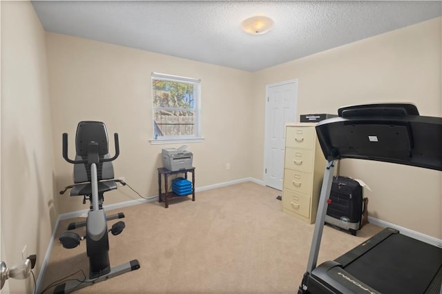 workout room with light colored carpet and a textured ceiling