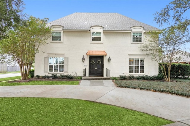 french country inspired facade with a front lawn