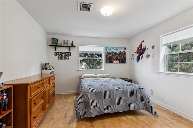 bedroom featuring light hardwood / wood-style flooring and multiple windows