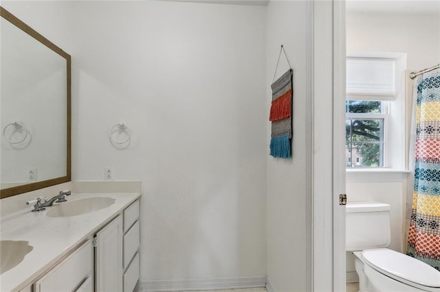 bathroom with walk in shower, vanity, and toilet