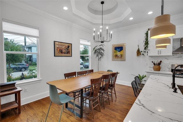 dining room featuring a chandelier, crown molding, a raised ceiling, and dark hardwood / wood-style flooring