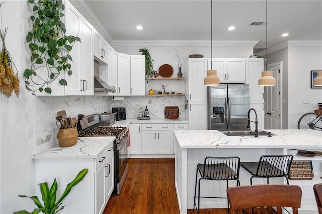 kitchen featuring stainless steel appliances, white cabinetry, sink, and pendant lighting