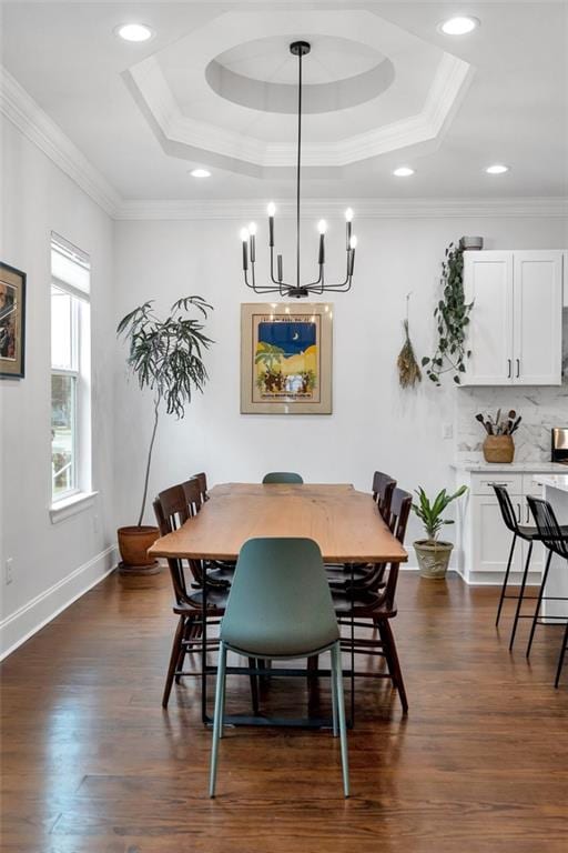 dining space featuring ornamental molding, dark hardwood / wood-style flooring, and a tray ceiling