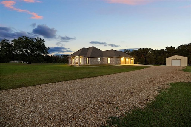 property exterior at dusk with a lawn, an outdoor structure, and a garage