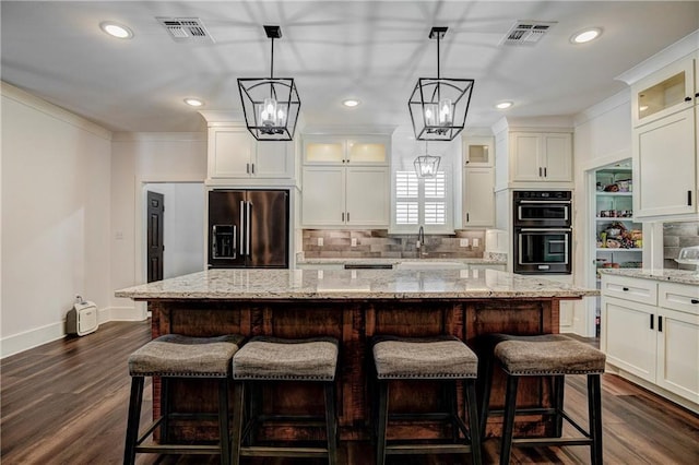 kitchen featuring dark wood-type flooring, decorative backsplash, a center island, and stainless steel appliances