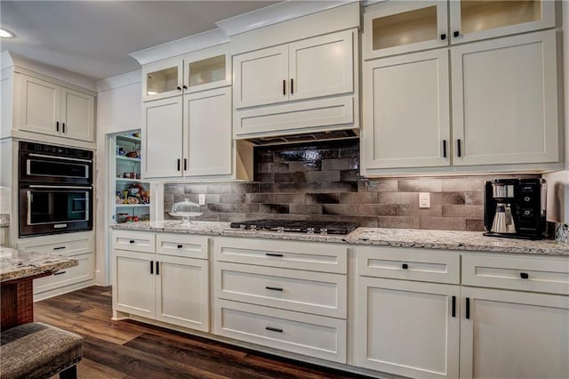 kitchen with white cabinets, decorative backsplash, double oven, dark hardwood / wood-style flooring, and stainless steel gas cooktop