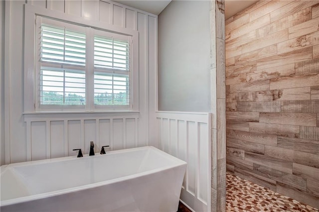 bathroom with wooden walls, sink, and shower with separate bathtub