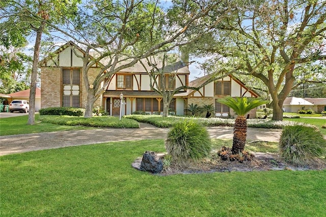 tudor home featuring a front lawn