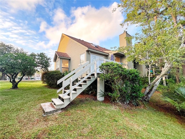 rear view of house featuring a lawn