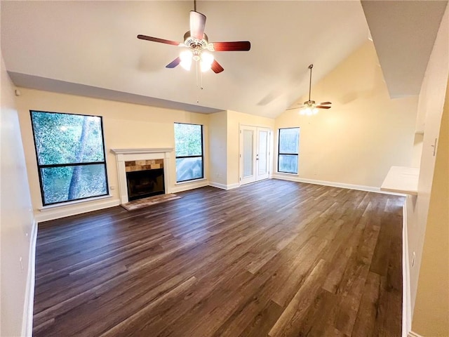 unfurnished living room featuring ceiling fan, high vaulted ceiling, a tile fireplace, and dark hardwood / wood-style flooring