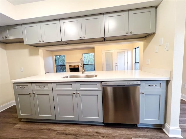 kitchen with dark hardwood / wood-style floors, gray cabinets, sink, stainless steel dishwasher, and kitchen peninsula