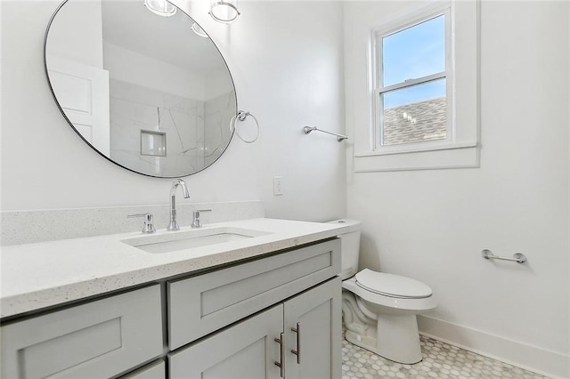 bathroom featuring toilet, a shower, and vanity