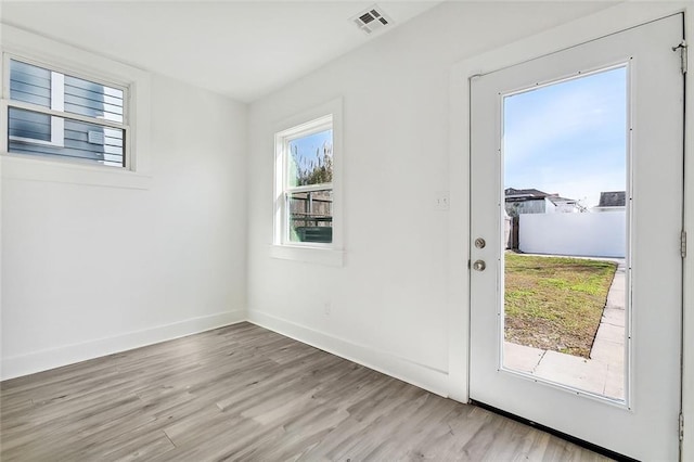 doorway to outside with light hardwood / wood-style floors and a healthy amount of sunlight