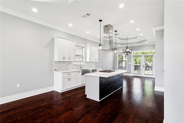 kitchen featuring island range hood, decorative light fixtures, a center island, white cabinets, and dark wood-type flooring