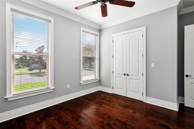 unfurnished bedroom featuring ceiling fan, multiple windows, dark hardwood / wood-style flooring, and crown molding