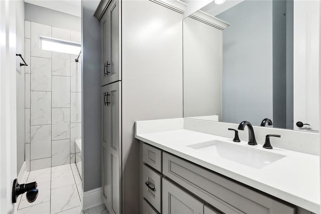 bathroom with vanity, a tile shower, and crown molding