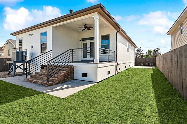 rear view of house with central AC unit, a patio area, a lawn, and ceiling fan