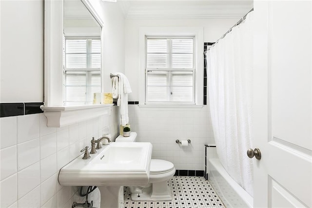 bathroom with tile walls, toilet, shower / tub combo with curtain, and crown molding