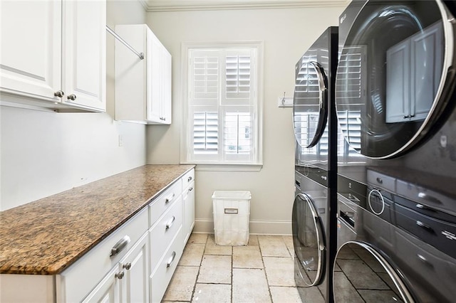 laundry room with stacked washer / dryer, cabinets, and ornamental molding