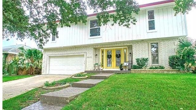 view of front of house featuring a garage, french doors, and a front yard