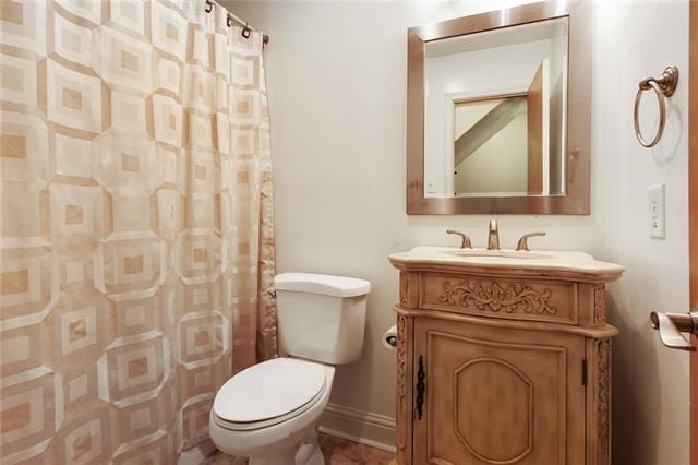 bathroom with curtained shower, vanity, and toilet