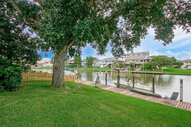 dock area with a water view and a lawn