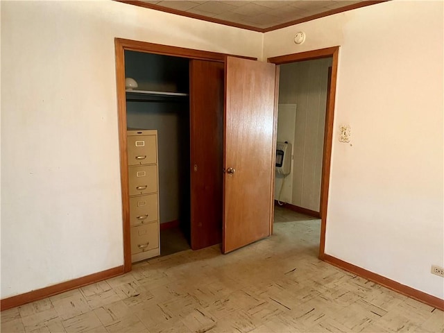 unfurnished bedroom featuring a closet and ornamental molding