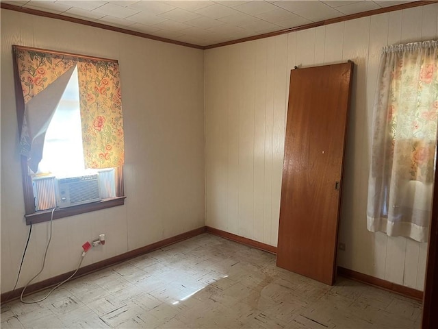 spare room featuring wood walls, cooling unit, and crown molding