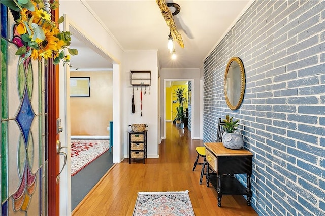 hallway featuring brick wall, hardwood / wood-style flooring, and crown molding