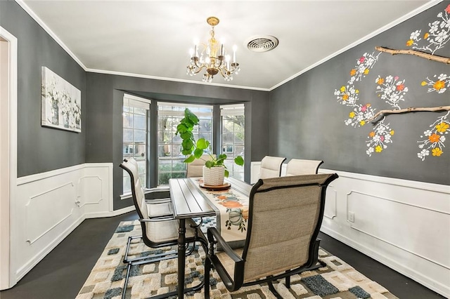 dining area with ornamental molding and a notable chandelier