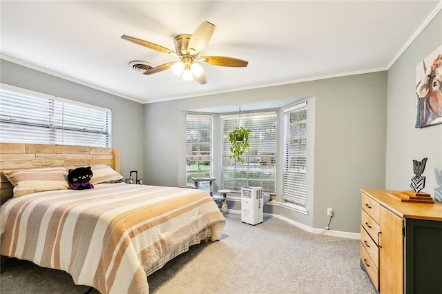 carpeted bedroom with ceiling fan and ornamental molding