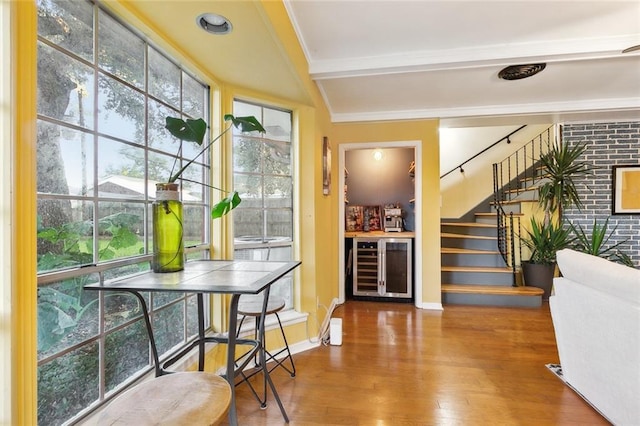 bar with hardwood / wood-style floors and beverage cooler